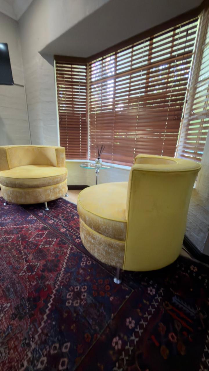 Golden armchairs beside shuttered windows in Room 7