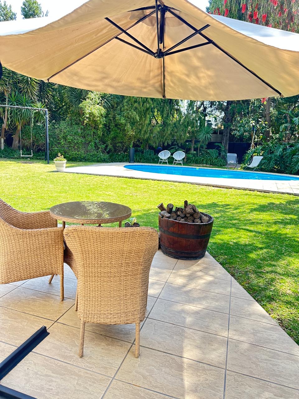 Poolside patio with umbrella and outdoor seating at Cherry Nest